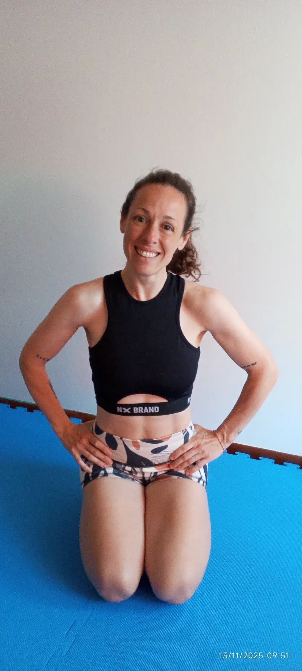 Mariana sonriendo, sentada en la colchoneta
